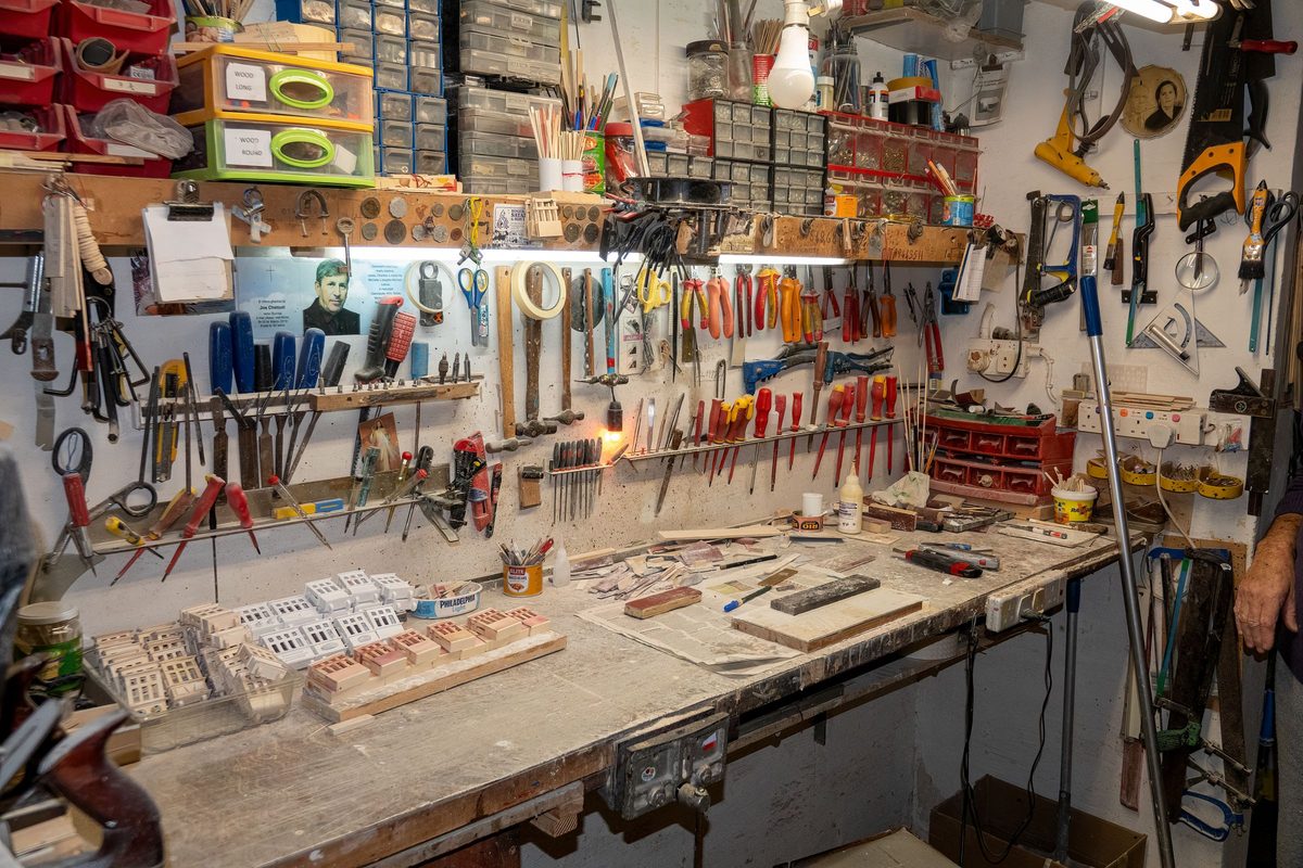 A workshop wall hung with hand tools