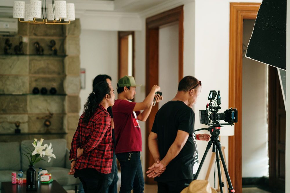 A small crew filming a renovation inside a room