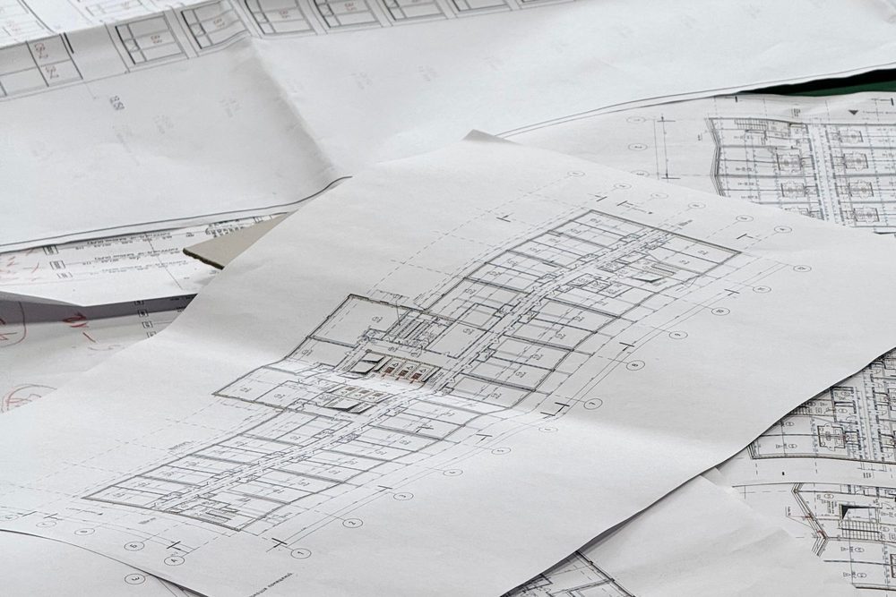 Building plans and drawings spread across a table