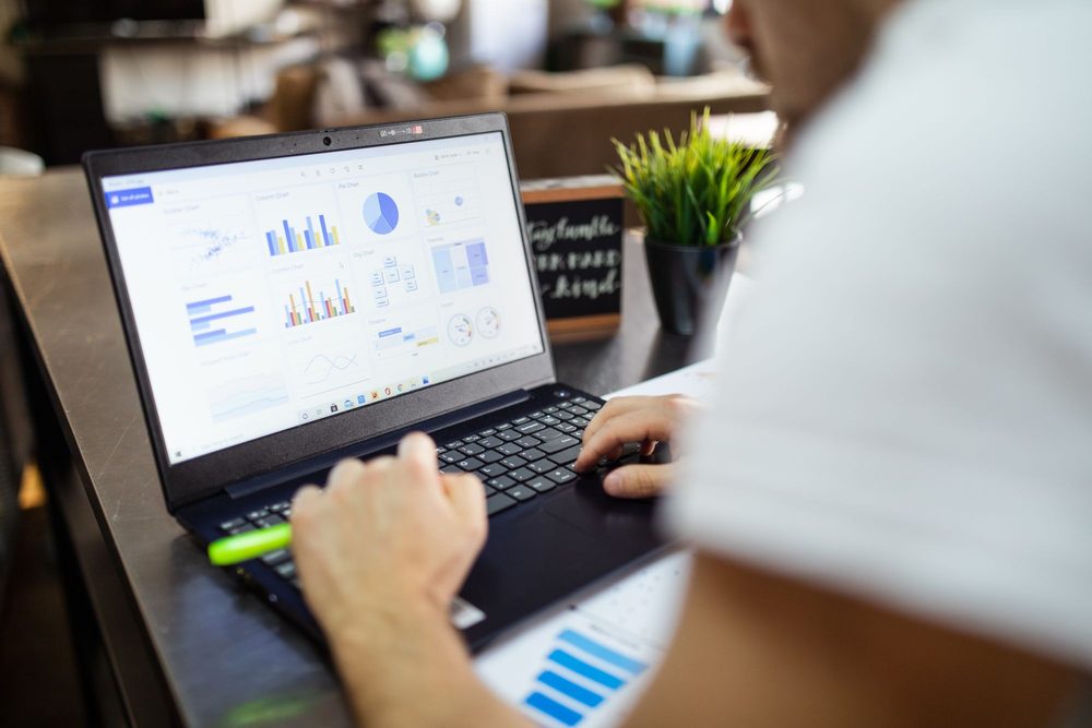 A laptop showing a spreadsheet on a work desk
