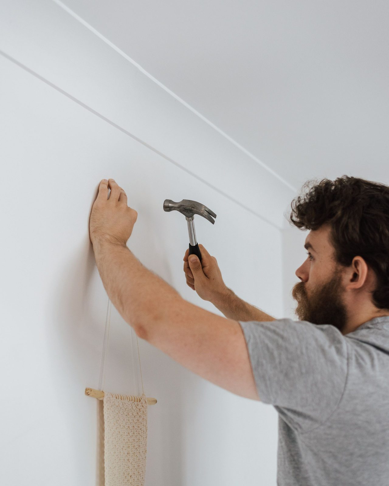 Someone hammering a fixing into an interior wall